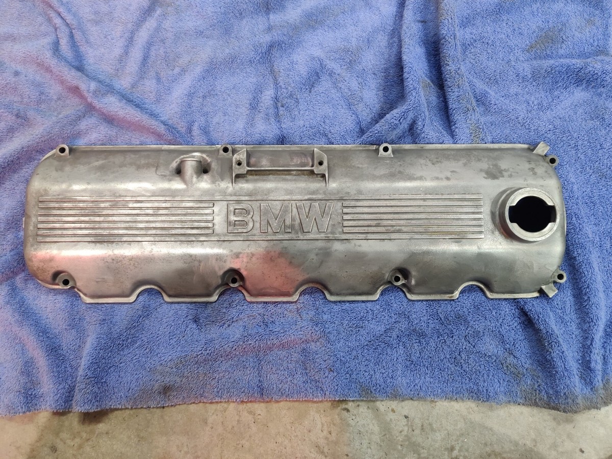 An older high-mileage engine with a metal valve cover and the gasket edge visible near the top of the cylinder head