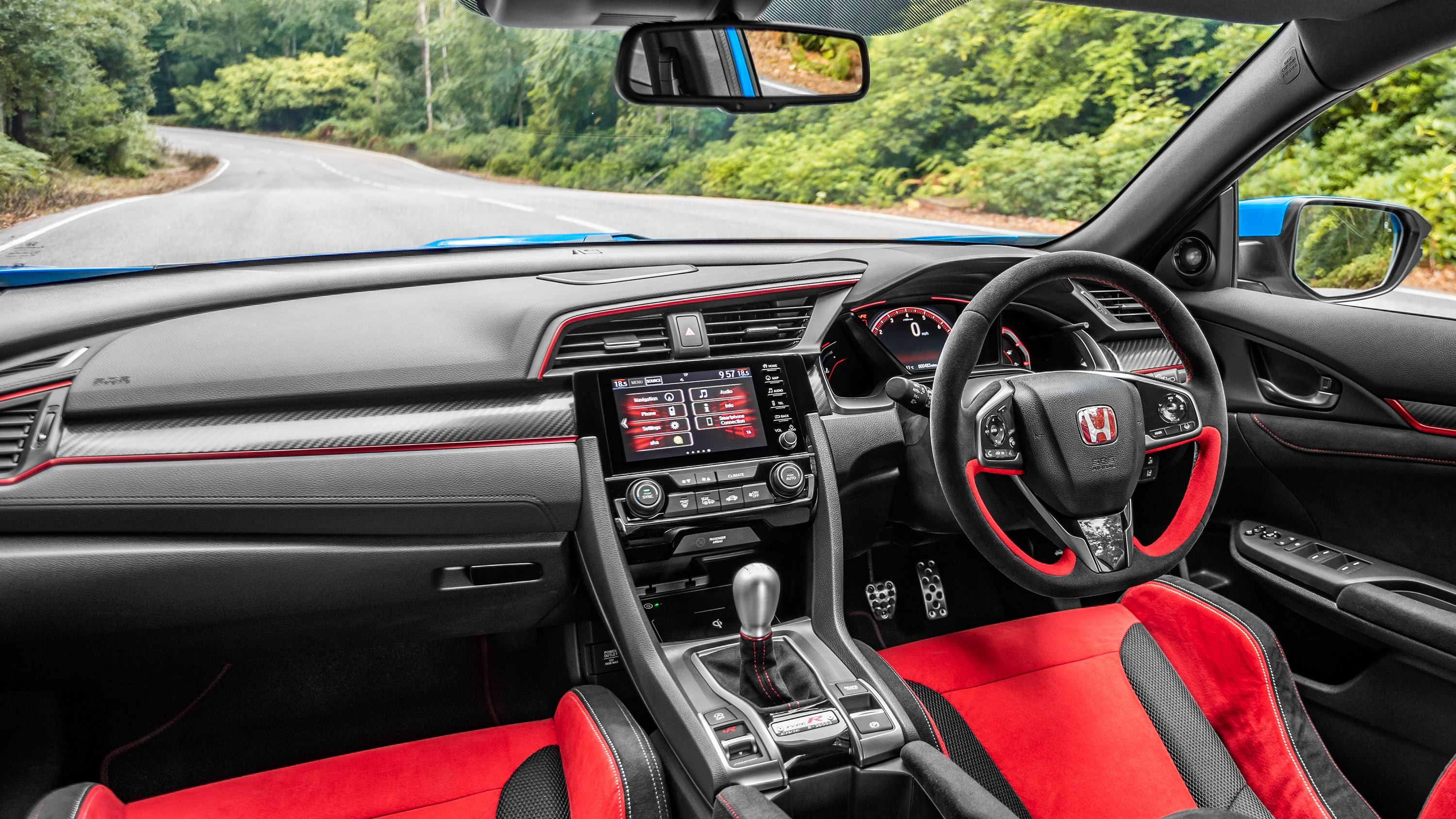 Interior view of a Honda Civic Type R showing the front seats and center console, emphasizing a sporty cabin layout.