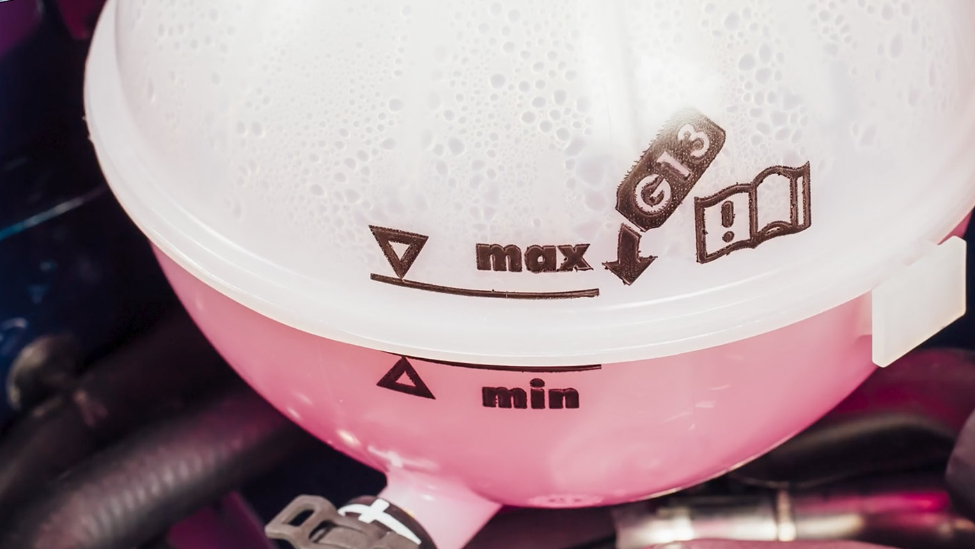 Translucent coolant expansion tank showing MIN and MAX markings and the coolant level